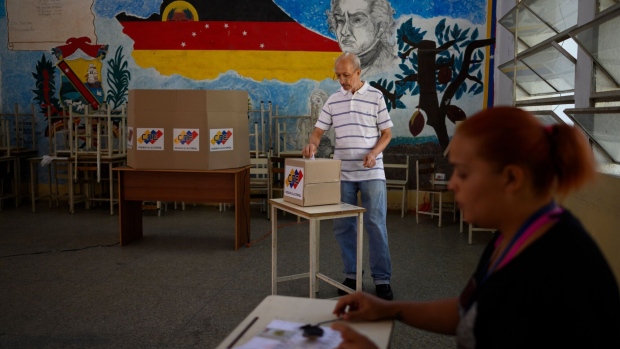 A voter casts a ballot at a polling station during a referendum vote ain Caracas, Venezuela, on Sunday, Dec. 3, 2023. Following massive offshore oil discoveries in the region by Exxon Mobil Corp. and others, and with elections approaching, President Maduro is inflaming regional tension by reviving a long-dormant border dispute over the area known as the Essequibo. Photographer: Gaby Oraa/Bloomberg