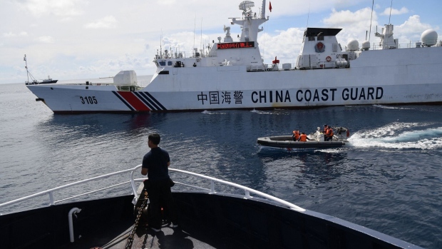 This photo taken on September 22, 2023 shows Chinese coast guard ship (R) blocking a Philippine Bureau of Fisheries and Aquatic Resources' (BFAR) ship (L) while its personnel aboard a rigid hull inflatable boat sailing past the Philippine ship as it neared the Chinese-controlled Scarborough Shoal in the disputed South China Sea.  Photographer: Ted Aljibe/AFP/Getty Images