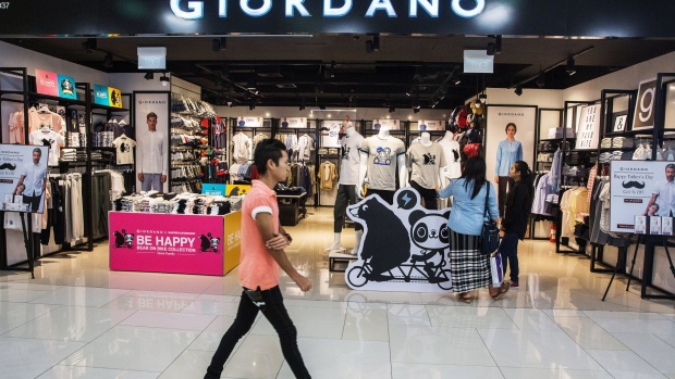 A customer walks past a Giordano International Ltd. store inside the Junction City mall in Yangon, Myanmar on Friday, June 16, 2017. A pariah state for decades, Myanmar’s recent emergence from economic isolation has attracted foreign companies and investors intrigued by the Southeast Asian nation’s untapped potential, abundant natural resources and low wage workforce. Yet some of the initial euphoria over the long-term outlook for one of the world’s last frontier markets is waning. Photographer: Taylor Weidman/Bloomberg