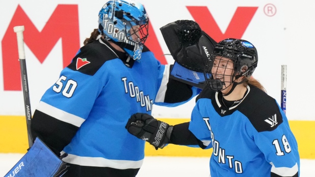 Toronto's Jesse Compher celebrates with goaltender Kristen Campbell after scoring against Minnesota
