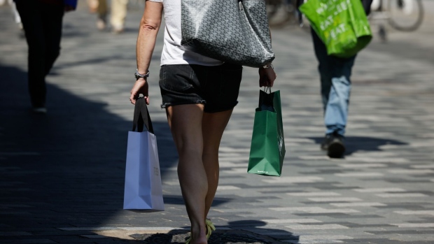 A shopper carrying bags along the high street in the Kingston district of London, UK, on Monday, May 20, 2024. The Bank of England will be able to cut interest rates “some time over the summer” if second round inflation pressures drop away as expected, Deputy Governor Ben Broadbent said. Photographer: Jason Alden/Bloomberg
