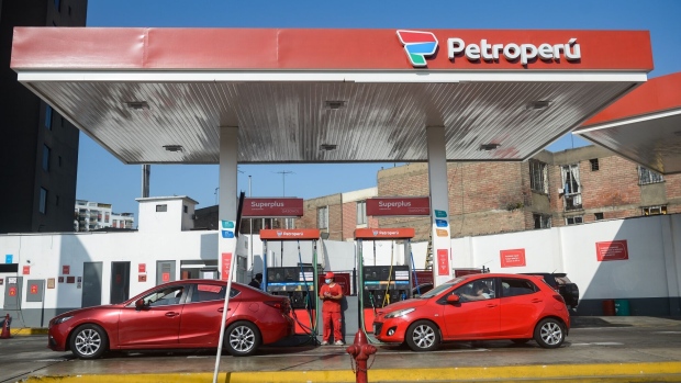 <p>Customers refuel vehicles at a Petroperu gas station in Lima, Peru.</p>