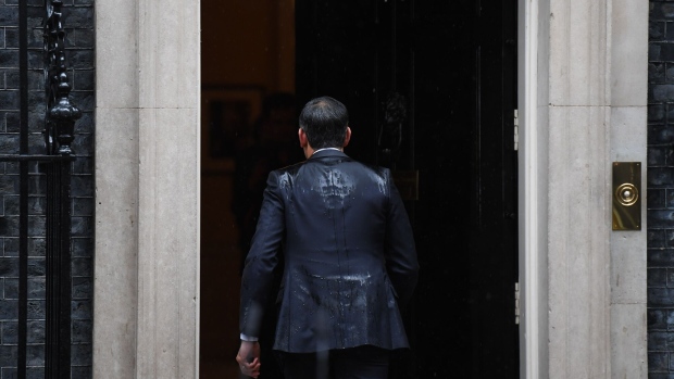 A rain-soaked Sunak returns to 10 Downing Street after announcing a general election.