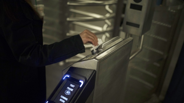 <p>A commuter swipes a MetroCard on a turnstile at a subway station in New York.</p>