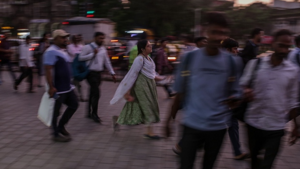 Pedestrians walk towards the Chhatrapati Shivaji Terminus (CST) train station at dusk in Mumbai, India, on Wednesday, Oct. 4, 2023. India’s central bank added more firepower to its inflation-busting toolkit as the nation’s entry into global bond index is set to test policymakers’ resolve to manage billions of dollars of inflows that could further fan price pressures. Photographer: Dhiraj Singh/Bloomberg