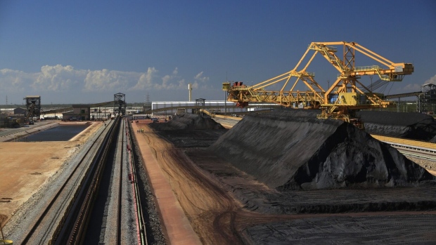 Iron ore sits in a pile near a conveyer belt in the Ferroport yard at the Acu Port in Sao Joao da Barra, Brazil, on Thursday, Dec. 4, 2014. Ferroport is a joint venture between Anglo American Plc and Prumo Logistica SA. The port, which has received 6.2 billion reais in investments since 2007, started operations in October when Anglo American Plc loaded a first iron-ore shipment from the Minas-Rio project. Photographer: Dado Galdieri/Bloomberg