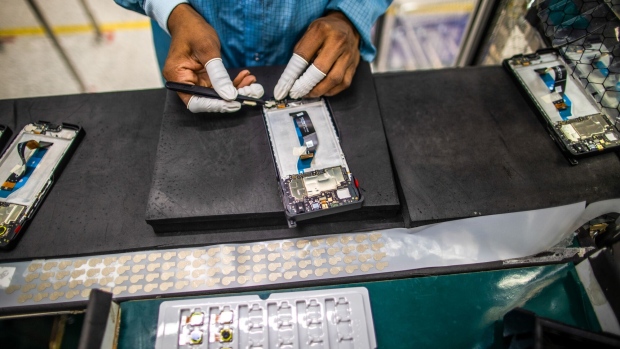 Employees work on a mobile phone assembly line in India.