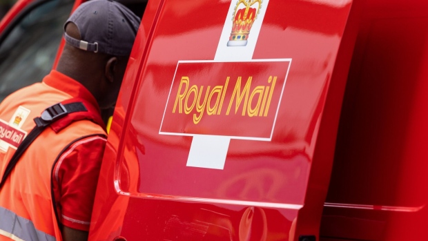 A postman removes letters and parcels from his Royal Mail vehicle in London.