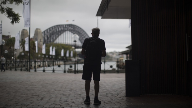 A man stands near Sydney Harbour Bridge in Sydney, Australia, on Tuesday, Nov. 28, 2023. Australia plans to enshrine an objective of superannuation in legislation as part of its agenda to maximize the benefits of the nations pension system, Treasurer Jim Chalmers said in a statement on Nov. 16. Photographer: Brent Lewin/Bloomberg