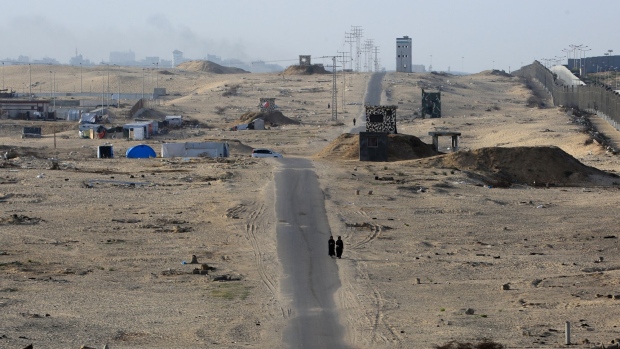 Two women walk through a deserted refugee camp in Rafah on May 22. Photographer: Eyad Baba/AFP/Getty Images