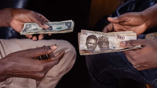 A customer exchanges naira banknotes for US dollar banknotes with a street currency dealer in Lagos.