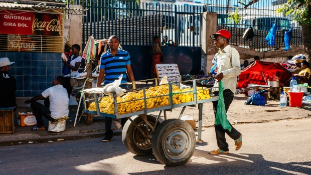 <p>A street trader wheels a cart laden with bananas along a street in Maputo, Mozambique.</p>