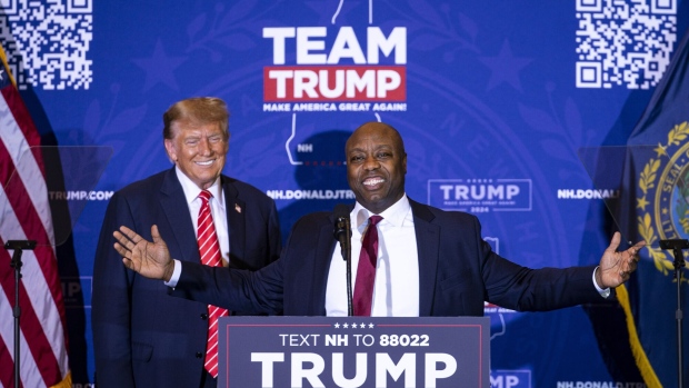 Senator Tim Scott, right, speaks as he stands next to former President Donald Trump during a campaign event.