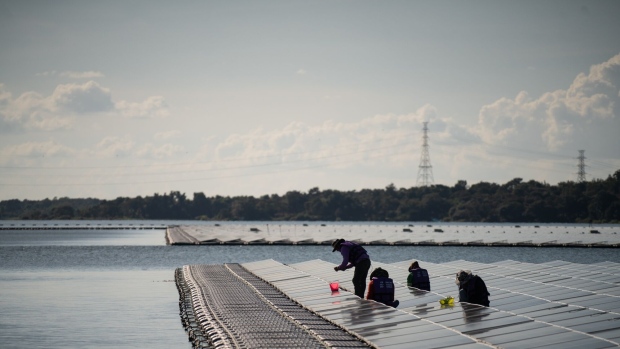 Workers on the floating solar farm at the Sirindhorn Dam, a hydro-floating solar hybrid project run by Electricity Generating Authority of Thailand (EGAT), on the Lam Dom Noi River in Sirindhorn District, Ubon Ratchathani, Thailand, on Tuesday, Nov. 2, 2021. While Thailand's emissions are relatively small -- pledges of developing economies are key with their growing energy consumption in the years to come -- the country's prime minister raised the ambition of their net-zero targets at the COP26 climate summit stating Thailand would aim to reach carbon neutrality by 2050.