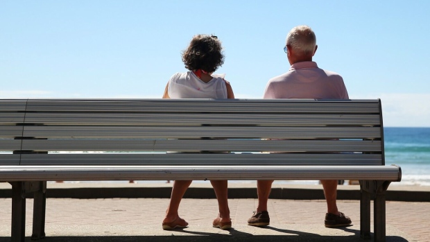 A woman and a man look out towards the beach while sitting on a bench in Sydney. Photographer: Brendon Thorne/Bloomberg