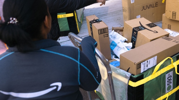 <p>An Amazon worker sorts packages for delivery.</p>