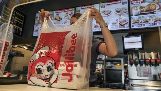 <p>A service assistant prepares an order at the Jollibee Foods Corp. restaurant in Taguig City, Manila. </p>