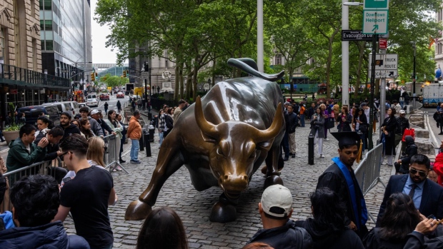 <p>Visitors at the "Charging Bull" statue near the New York Stock Exchange (NYSE) in New York, US, on Thursday, May 16, 2024.</p>