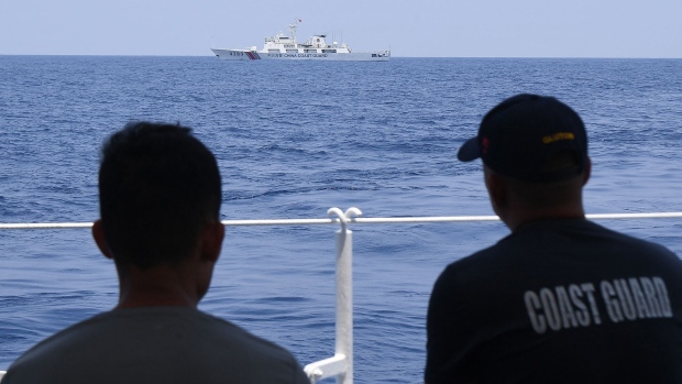 Philippine Coast Guard personnel monitor a China Coast Guard ship in the South China Sea in May. Photographer: Ted Aljibe/AFP/Getty Images