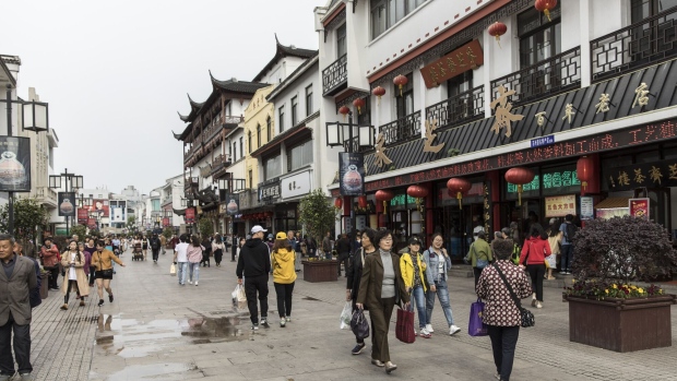 Pedestrians walk along Guanqian Street in Suzhou, China. Photographer: Qilai Shen/Bloomberg