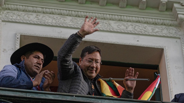 Luis Arce waves from the balcony of the presidential palace Wednesday after a failed coup attemp.