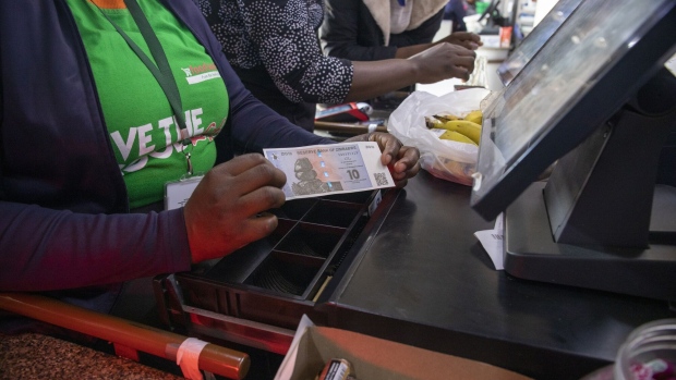 A supermarket till operator with a ZiG banknote in Harare.