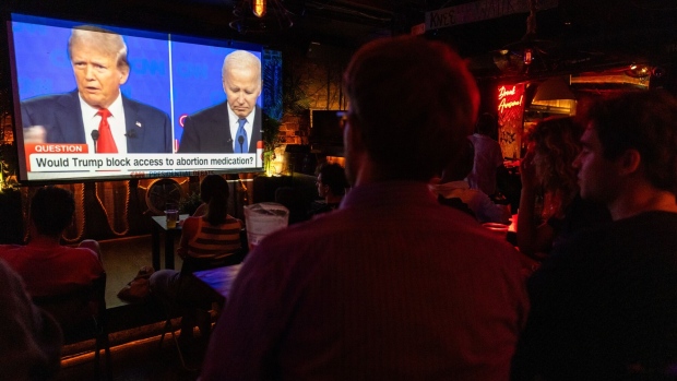 <p>People watch the presidential debate between Joe Biden and Donald Trump in New York City on June 27.</p>