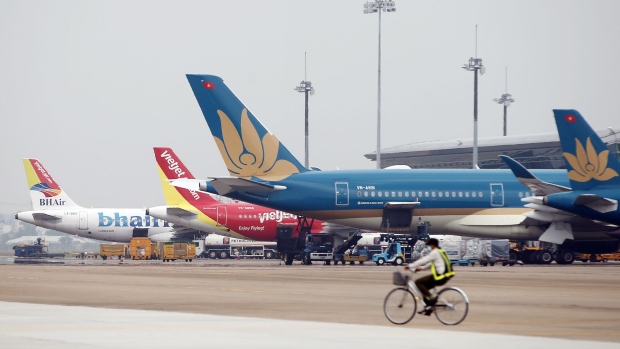 <p>A Vietnam Airlines JSC aircraft, right, near Ho Chi Minh City.</p>