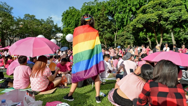 A LGBTQ+ supporter wrapped in a rainbow flag at Hong Lim Park in Singapore. Photographer: Roslan Rahman/AFP/Getty Images