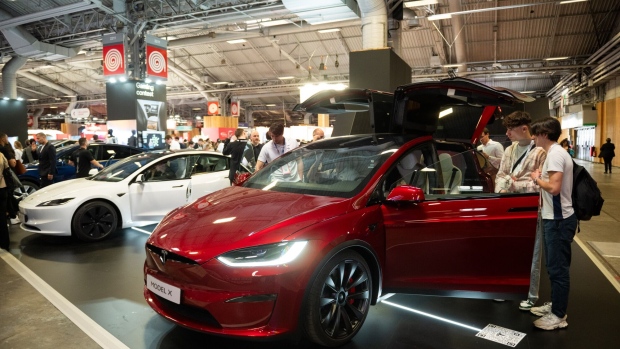 Attendees inspect a Tesla Inc. Model X on display at the VivaTech conference in Paris, France, on Thursday, May 23, 2024. The annual startup and technology events runs until May 25. Photographer: Benjamin Girette/Bloomberg