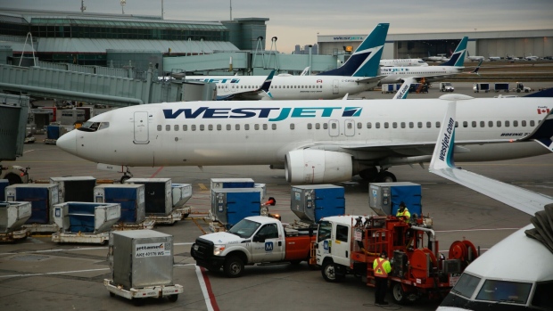 WestJet planes at Toronto Pearson International Airport in Toronto, Ontario, Canada, on Saturday, Dec. 9, 2023. The Greater Toronto Airports Authority expects a 10% increase in passenger traffic this holiday season, CBC reports. Photographer: David Kawai/Bloomberg