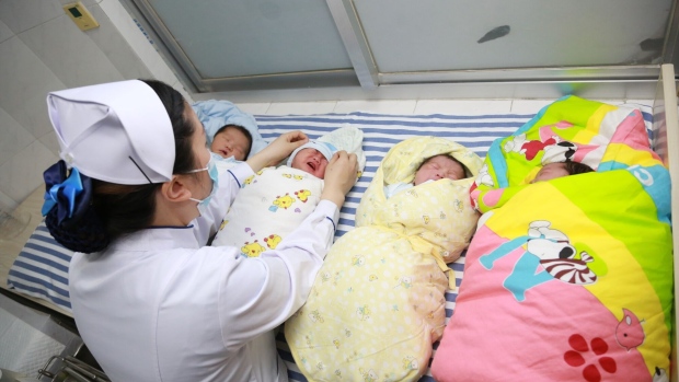A nurse takes care of newborn babies at a hospital in Hubei Province of China.  Photographer: Gong Bo/Visual China Group/Getty Images