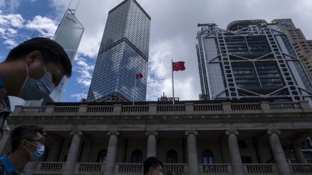 The flags of China, center, and the Hong Kong Special Administrative Region (HKSAR) fly above the Court of Final Appeal building as the Standard Chartered Plc building, from right, the HSBC Holdings Plc building, Cheung Kong Center, and the Bank of China Tower stand in Hong Kong, China, on Thursday, June 4, 2020. HSBC and Standard Chartered, the two British institutions that dominate Hong Kong's banking system, backed Beijing in the standoff over a proposed new security law, joining Jardine Matheson Holdings Ltd. and some of the city's biggest developers in wading into the political minefield of the former colony's future. Photographer: Roy Liu/Bloomberg