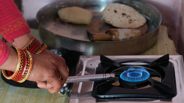 <p>A woman lights a stove in India.</p>
