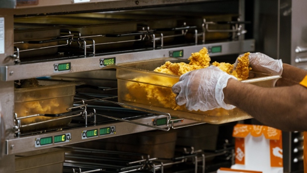 A worker holds a tray of fried chicken inside a Popeye's Louisiana Kitchen Inc. restaurant location in Latham, New York, US, on Thursday, April 25, 2024. Restaurant Brands International Inc. is scheduled to release earnings figures on April 30. Photographer: Angus Mordant/Bloomberg